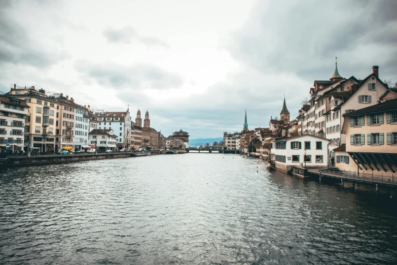 a river running through a city with a tall building next to it