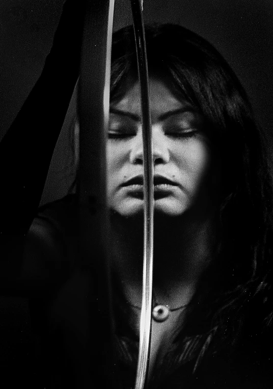 a person in black jacket behind the blinds with the knife sticking out