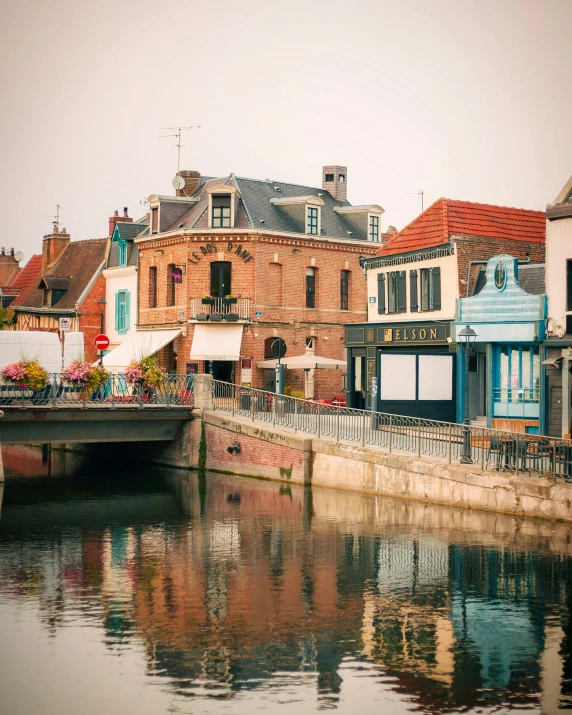 a river with a few buildings reflecting in the water