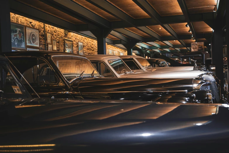 a row of antique cars parked inside a car museum