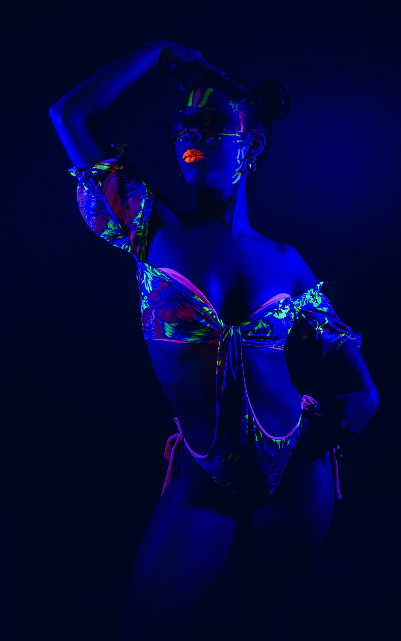 a woman in neon clothing poses with her hands on her hips