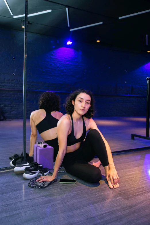 a young woman is kneeling down on the floor next to a purple bag