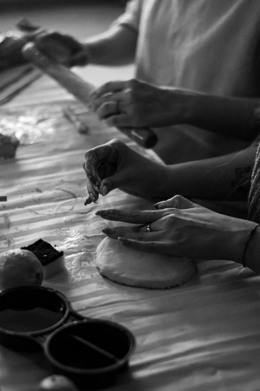 two people sitting at a table and holding plates with food on them