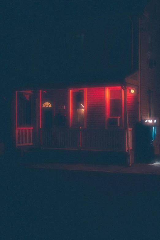 two people sit outside of a restaurant at night