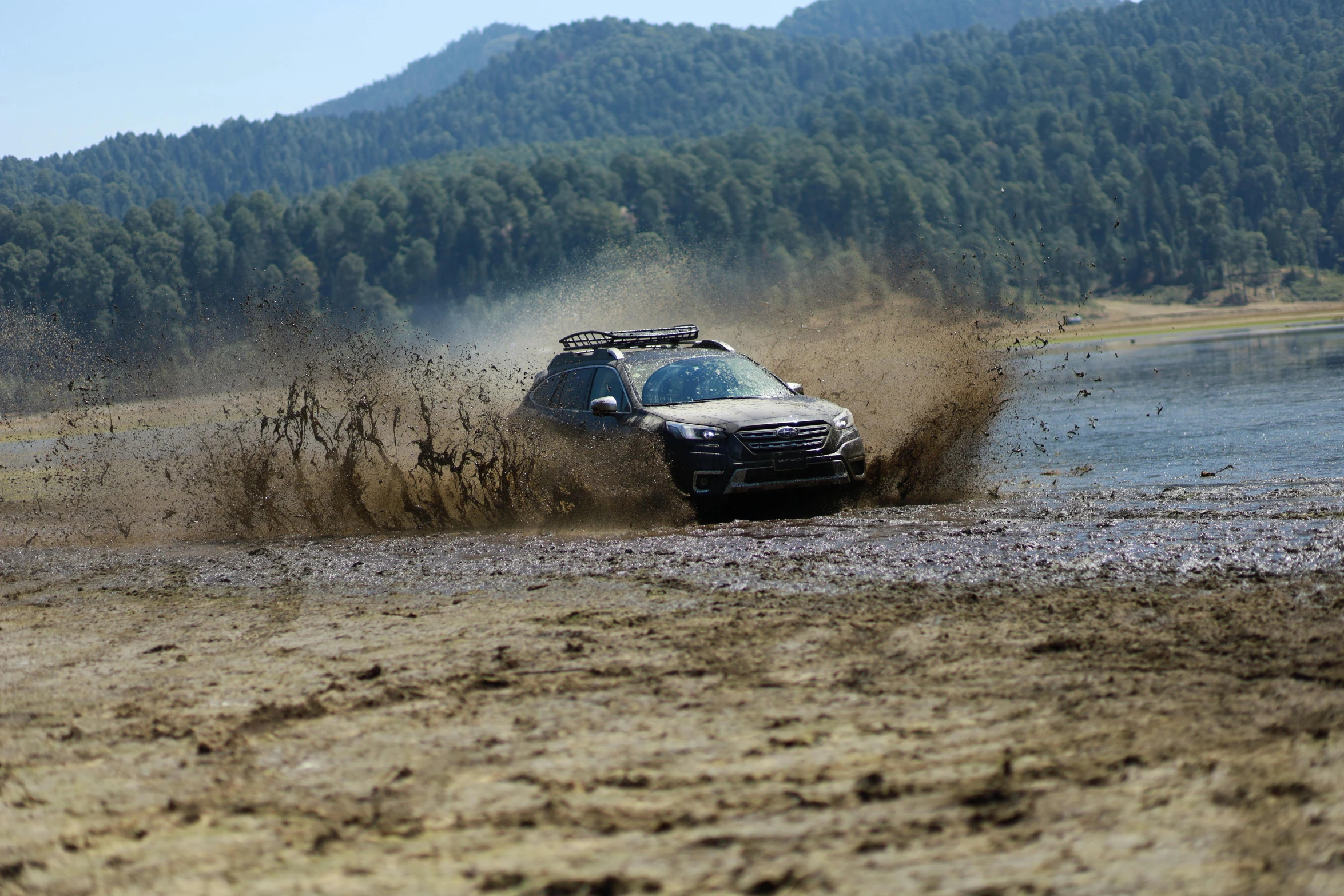 a car is driving through the mud in a river