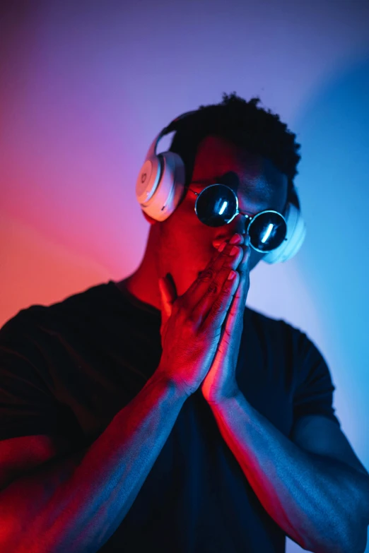 a man wearing headphones holding a pair of glasses