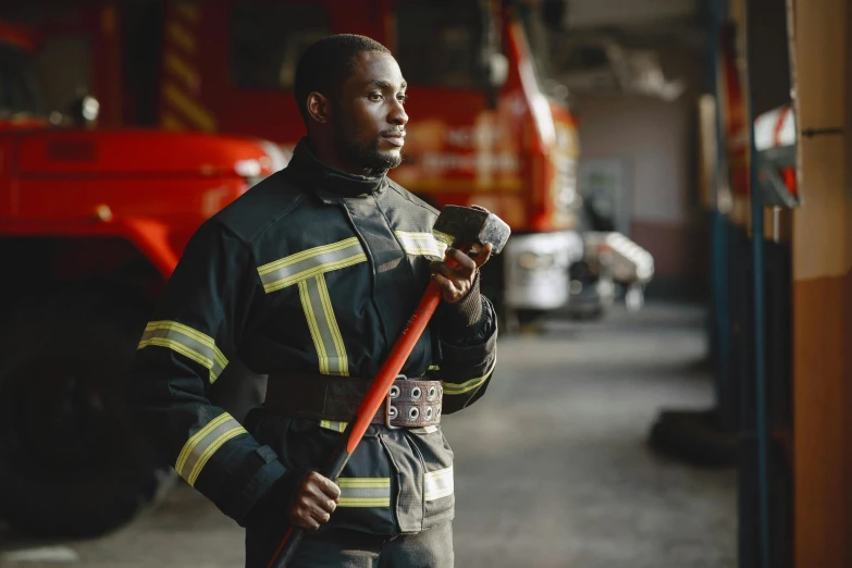 fireman holding hose with helmet on stands in a garage