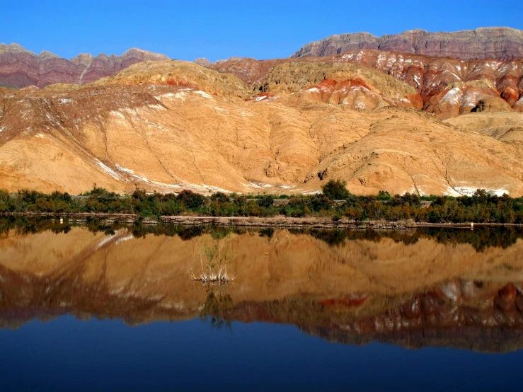 the mountains are reflected in a calm lake