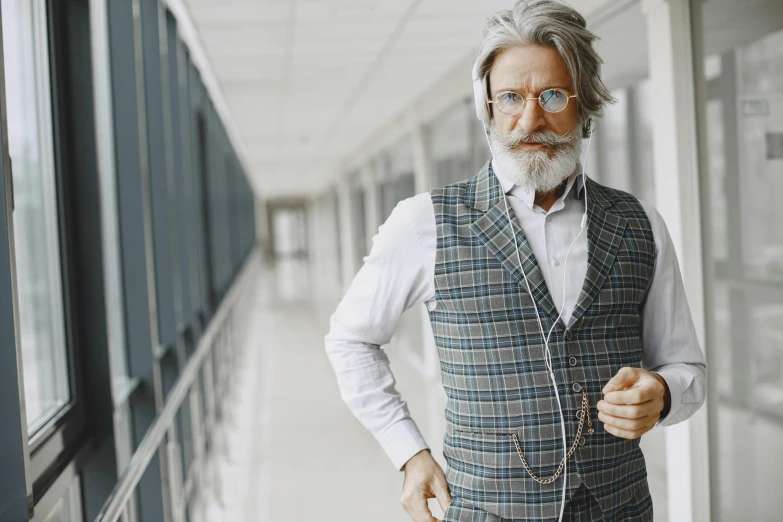 an older gentleman standing in an airport hallway with his hands on his hips