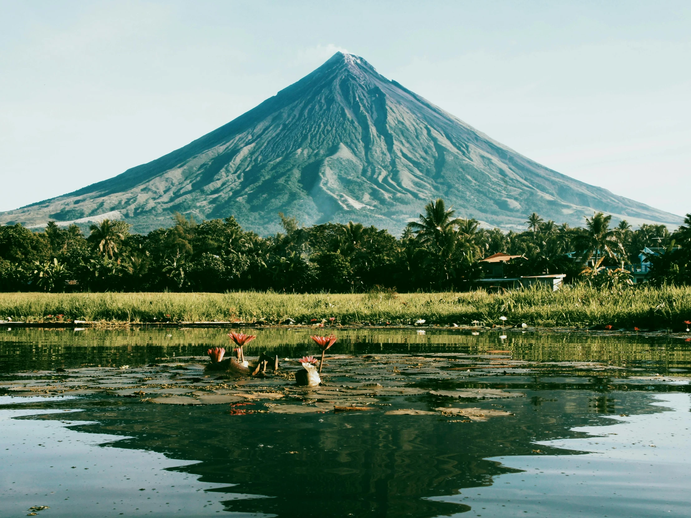 a mountain rising up behind a small lake