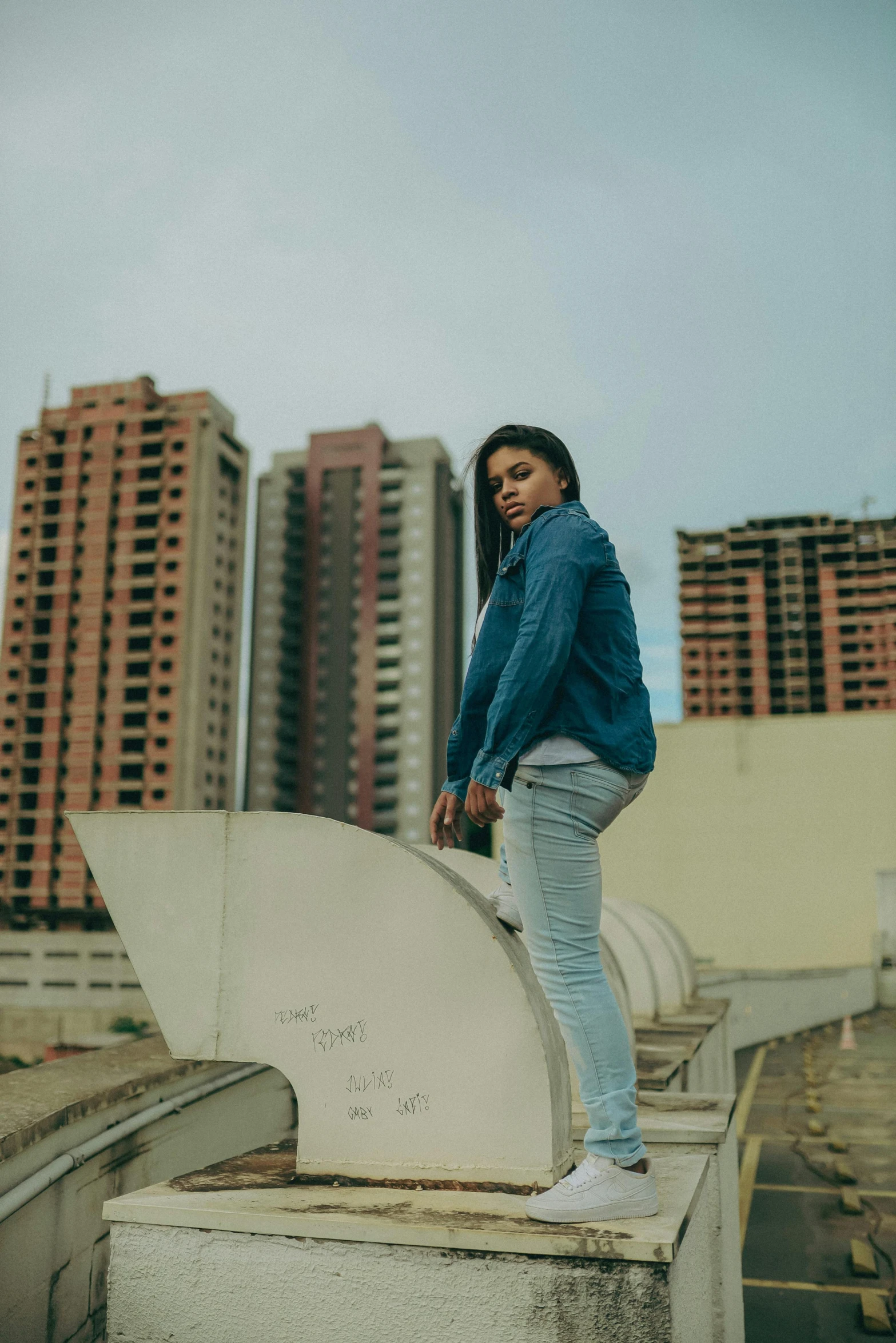 the woman in jeans and sneakers is talking on a cell phone