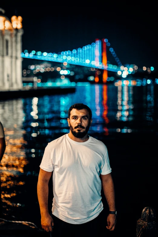 a man in white shirt standing near the water