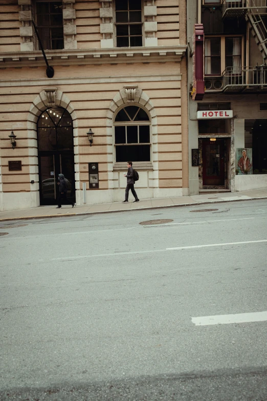 an older man is walking down the street in front of some old buildings