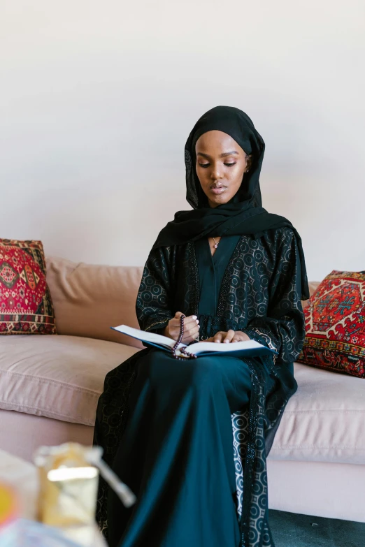 a woman sitting on top of a couch wearing a black outfit