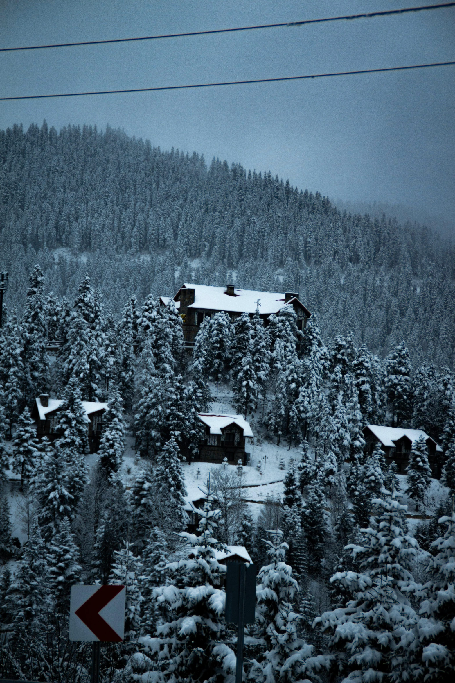 there are two houses with red arrow signs in the snow