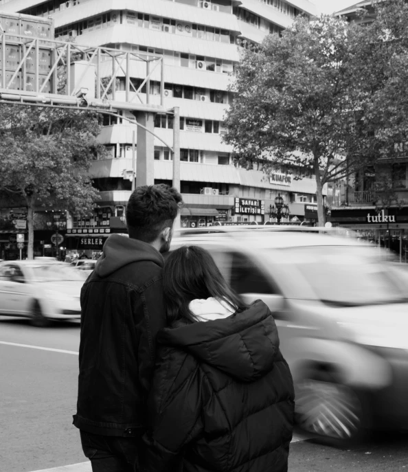 the man and woman are walking along the street