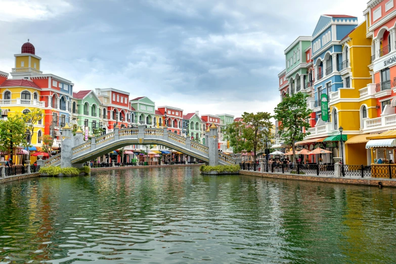 a river in a city with buildings and an old bridge