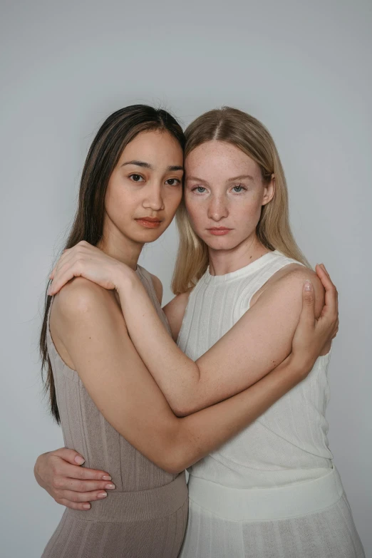 two women in beige posing for a po