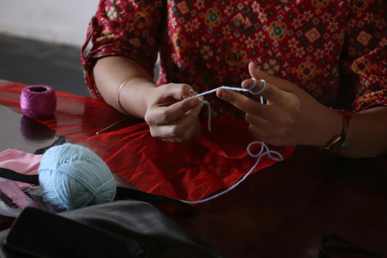 woman is knitting with a string and crochet hook