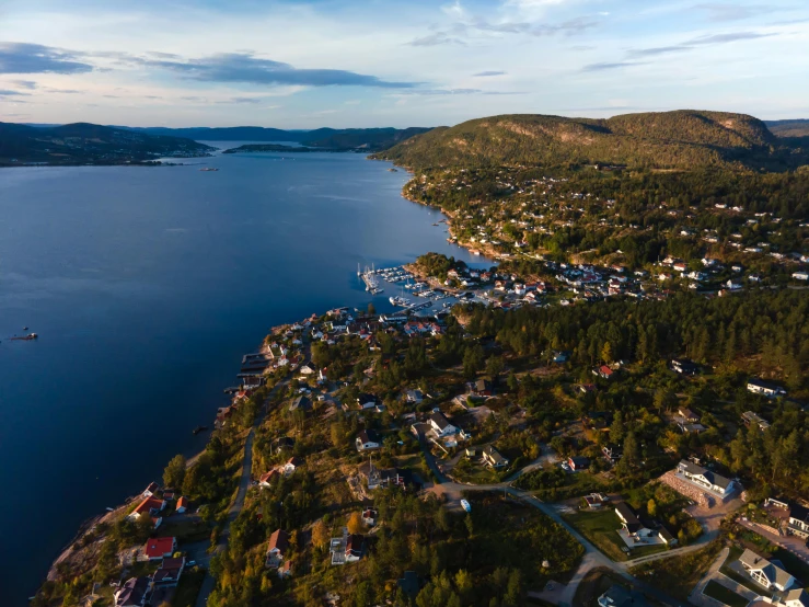 a lake with houses on the side and a mountain in the background