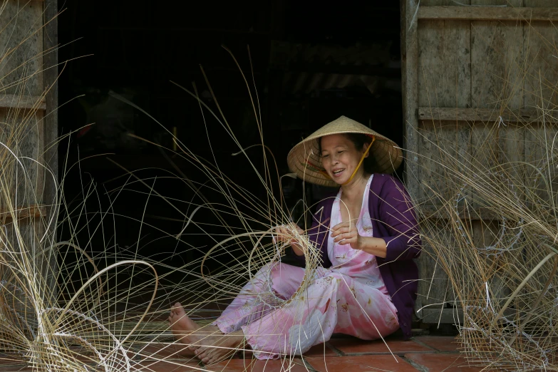 the woman in a hat sits outside a building