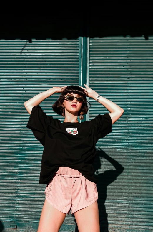 a woman in shorts and a black shirt poses