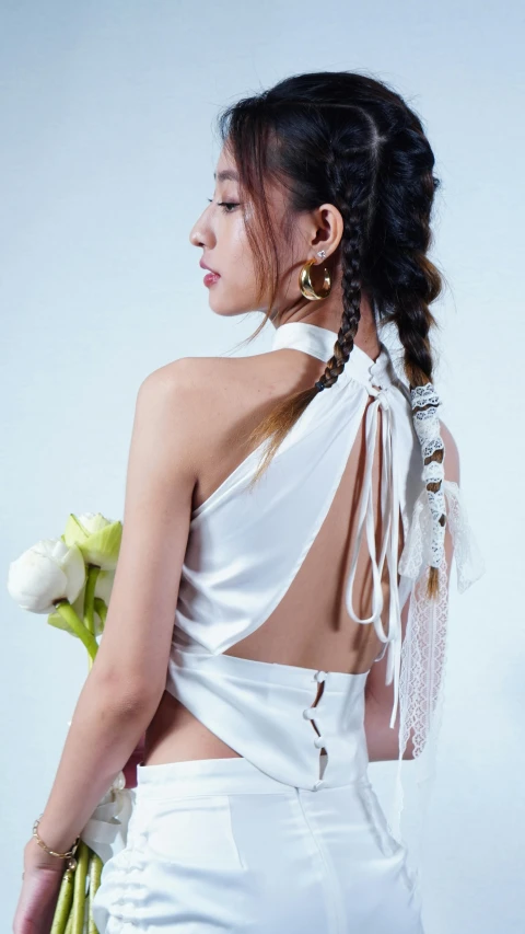 a woman wearing a very  white dress and holding flowers