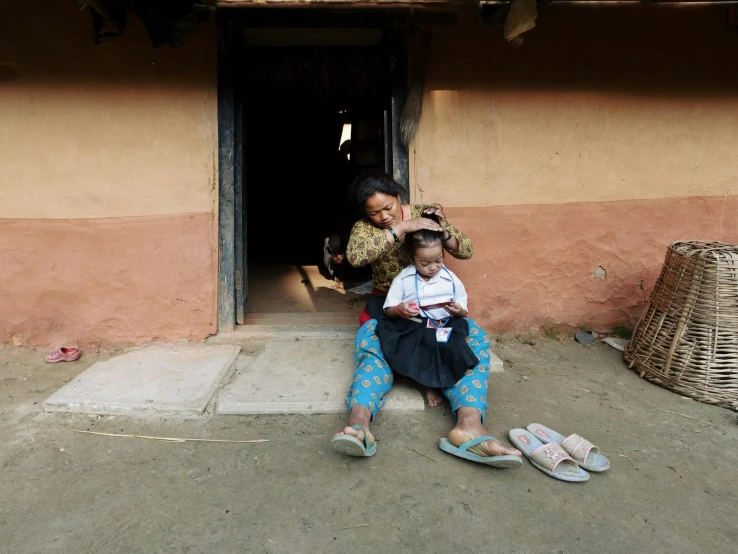 two women in front of their house brushing their hair