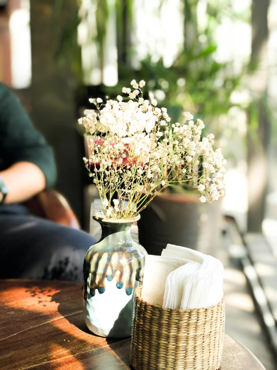 a vase of flowers and some papers on a table