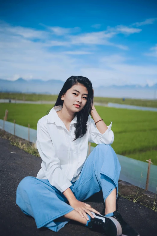 an asian woman in white shirt sitting on the ground
