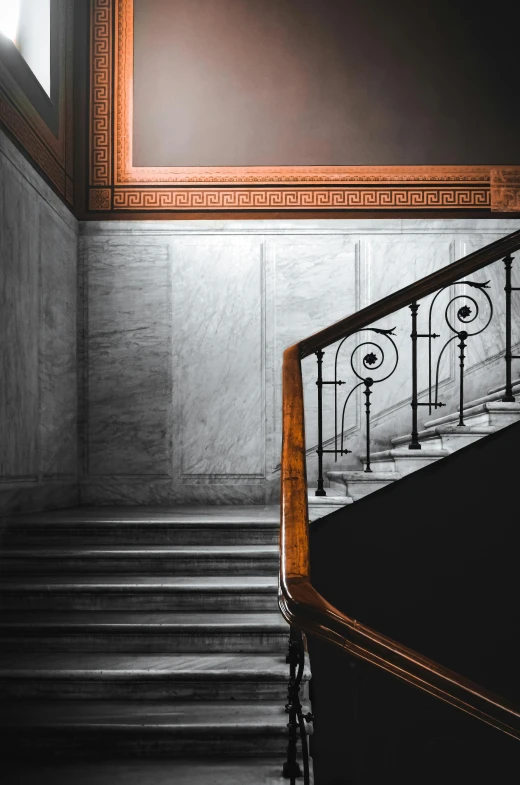 an old staircase with iron railing and wood handrail