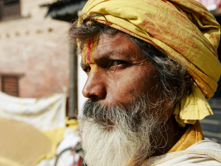 a man with a large, yellow beard stares away