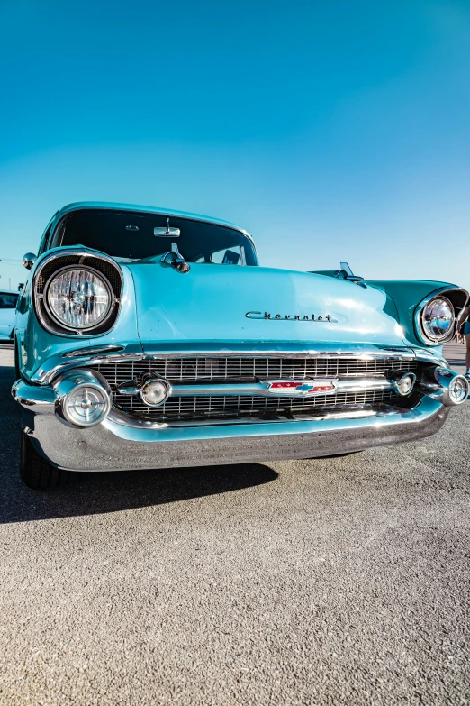 a classic car parked on the beach with the ocean in the background