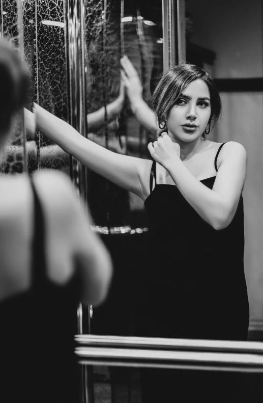 woman in black dress standing next to glass door