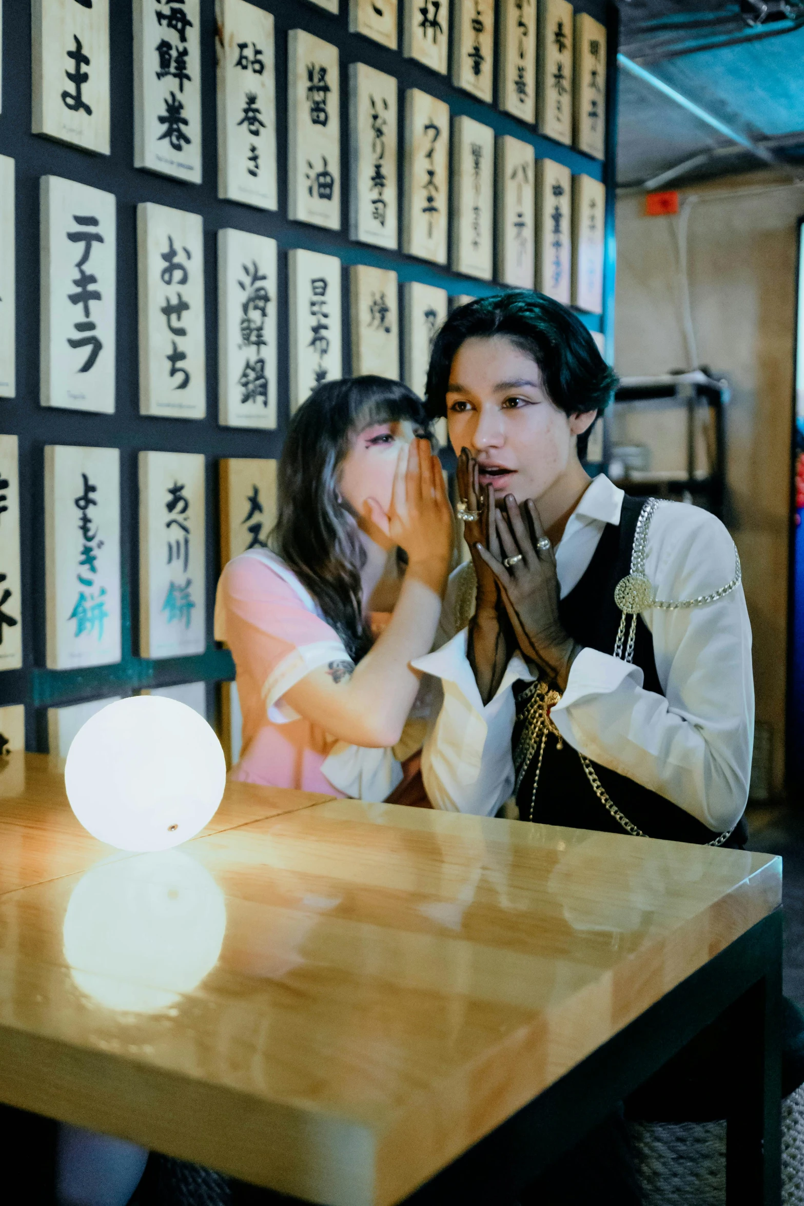 a man and woman praying in front of a number of oriental type letters