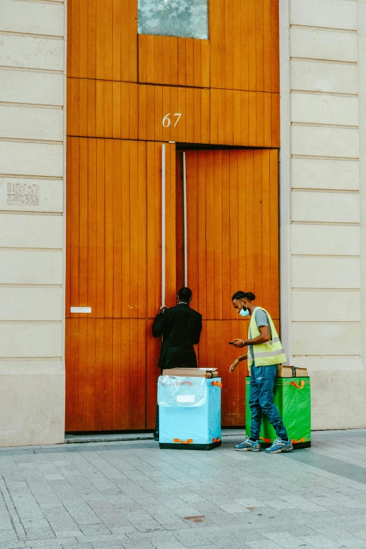 two people with luggage near a building door