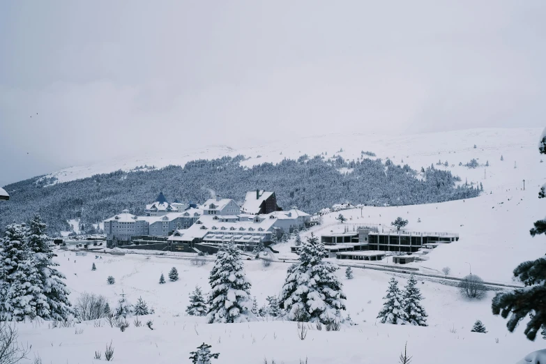 a snowy landscape shows houses on top of the mountain