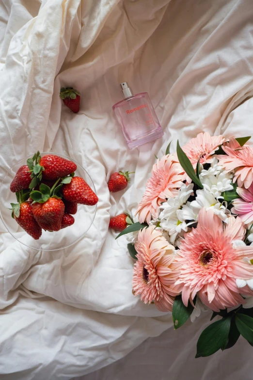 white flowers and some strawberries on a bed