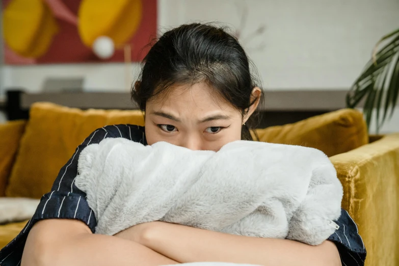 a woman is holding a towel over her face