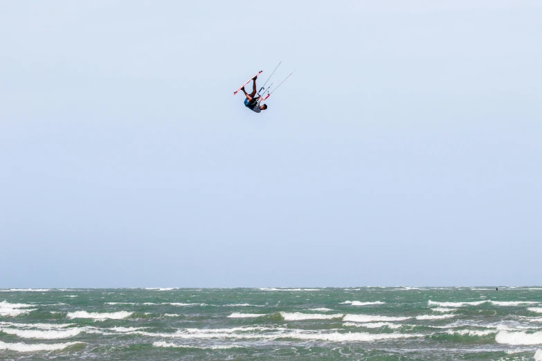 a para sailer is high in the air above the water