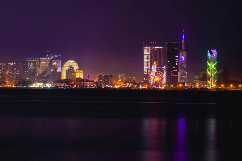 a night time view of a city lit with colored lights