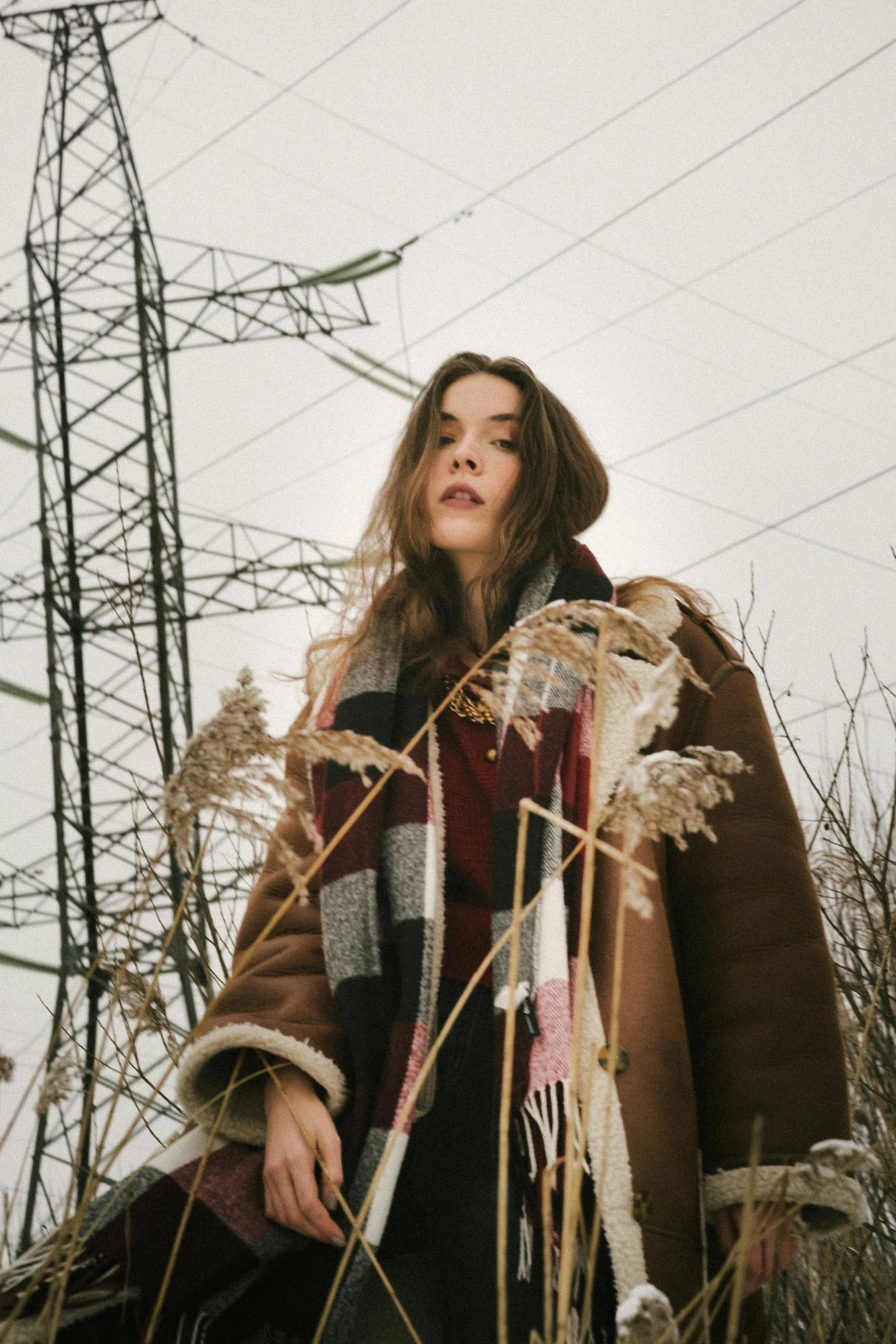 a woman stands outside behind a lot of power lines