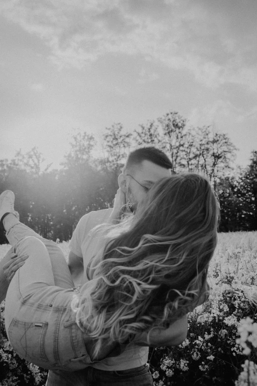 a woman and man in a field holding each other