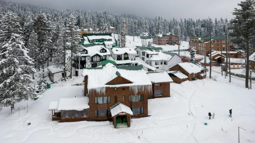 a small mountain village surrounded by trees in the snow