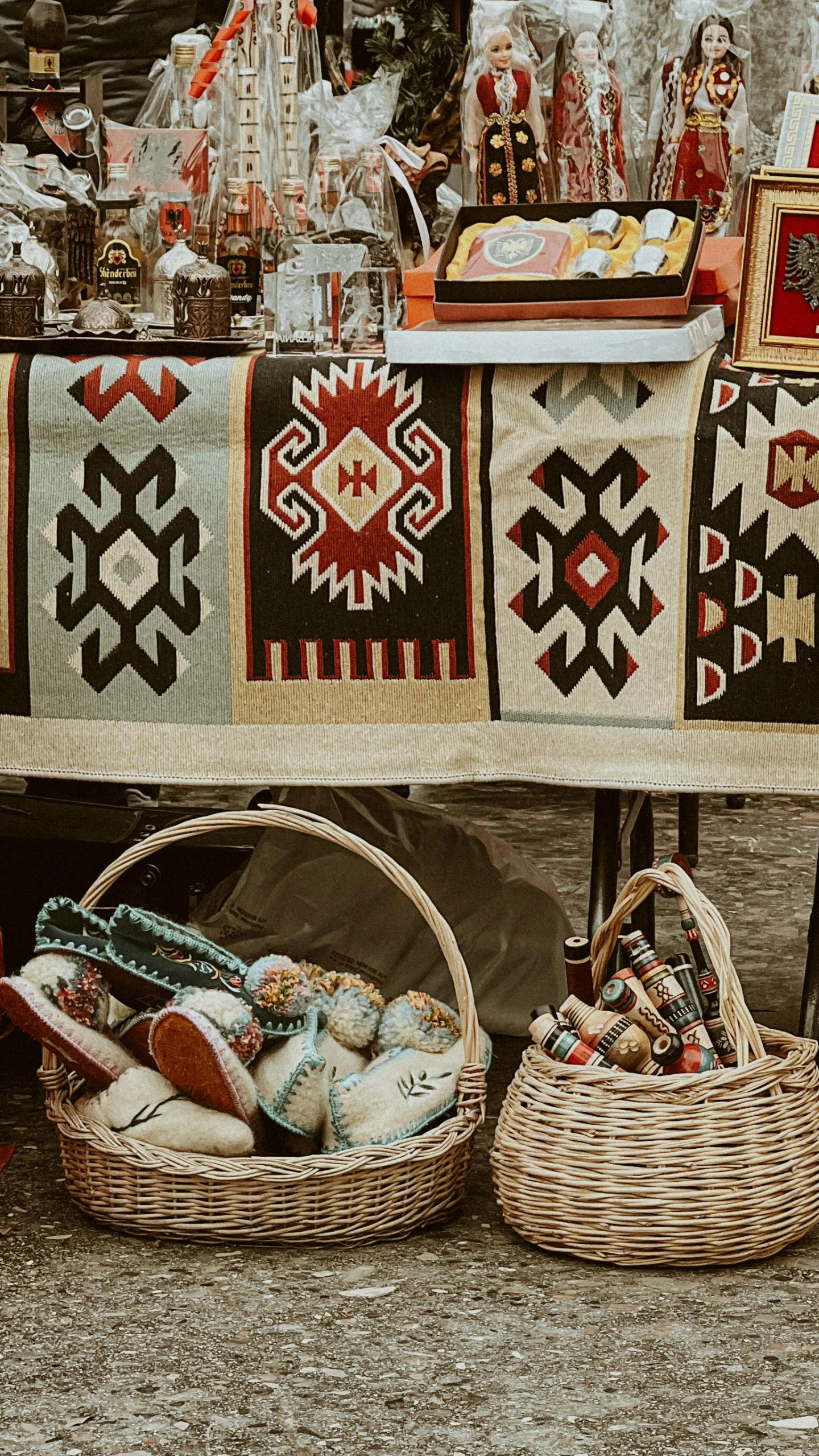 a street side market with baskets of food, baskets and blankets