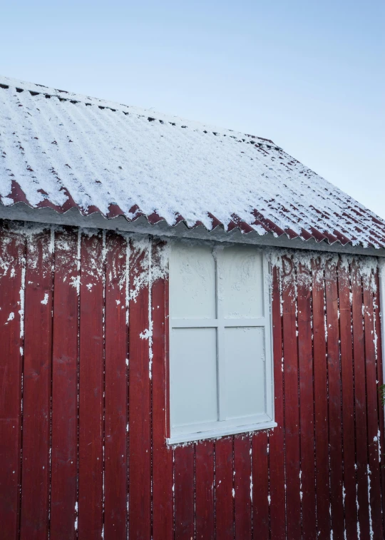 the barn's roof is covered in snow