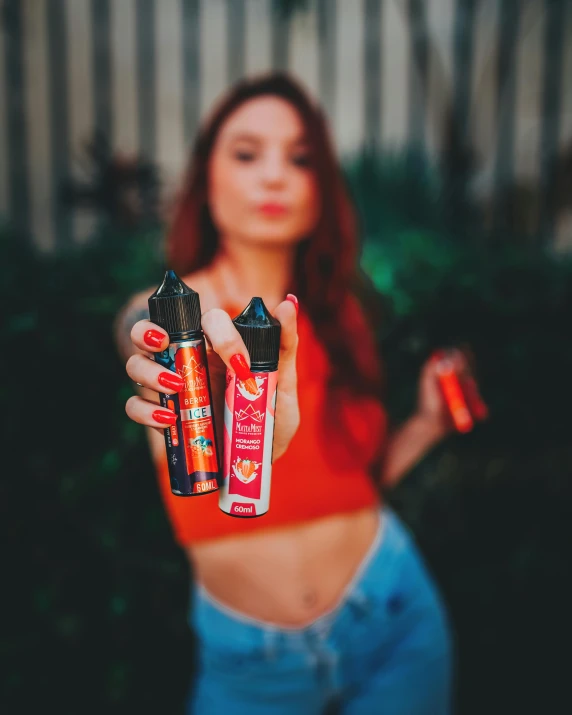 a woman holding three bottles of alcohol in her hands