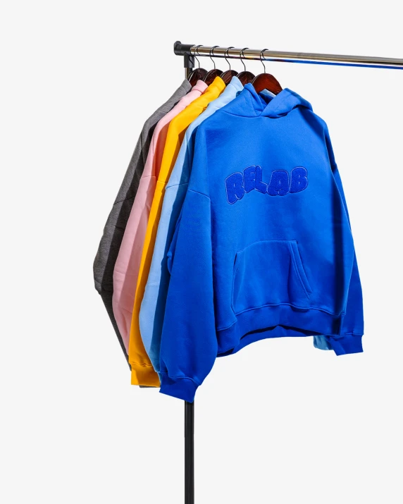 blue sweatshirts hung on a rack with hangers