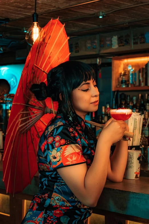 a girl holding a cocktail, and umbrella