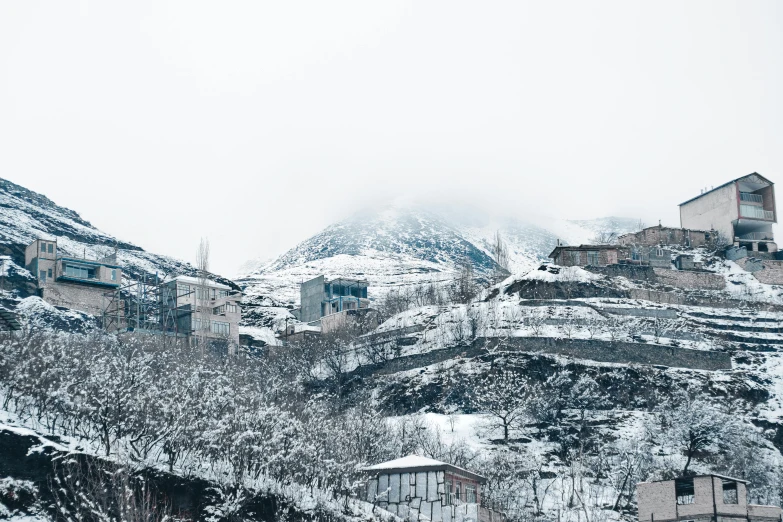 snow covered buildings with a mountain range in the background